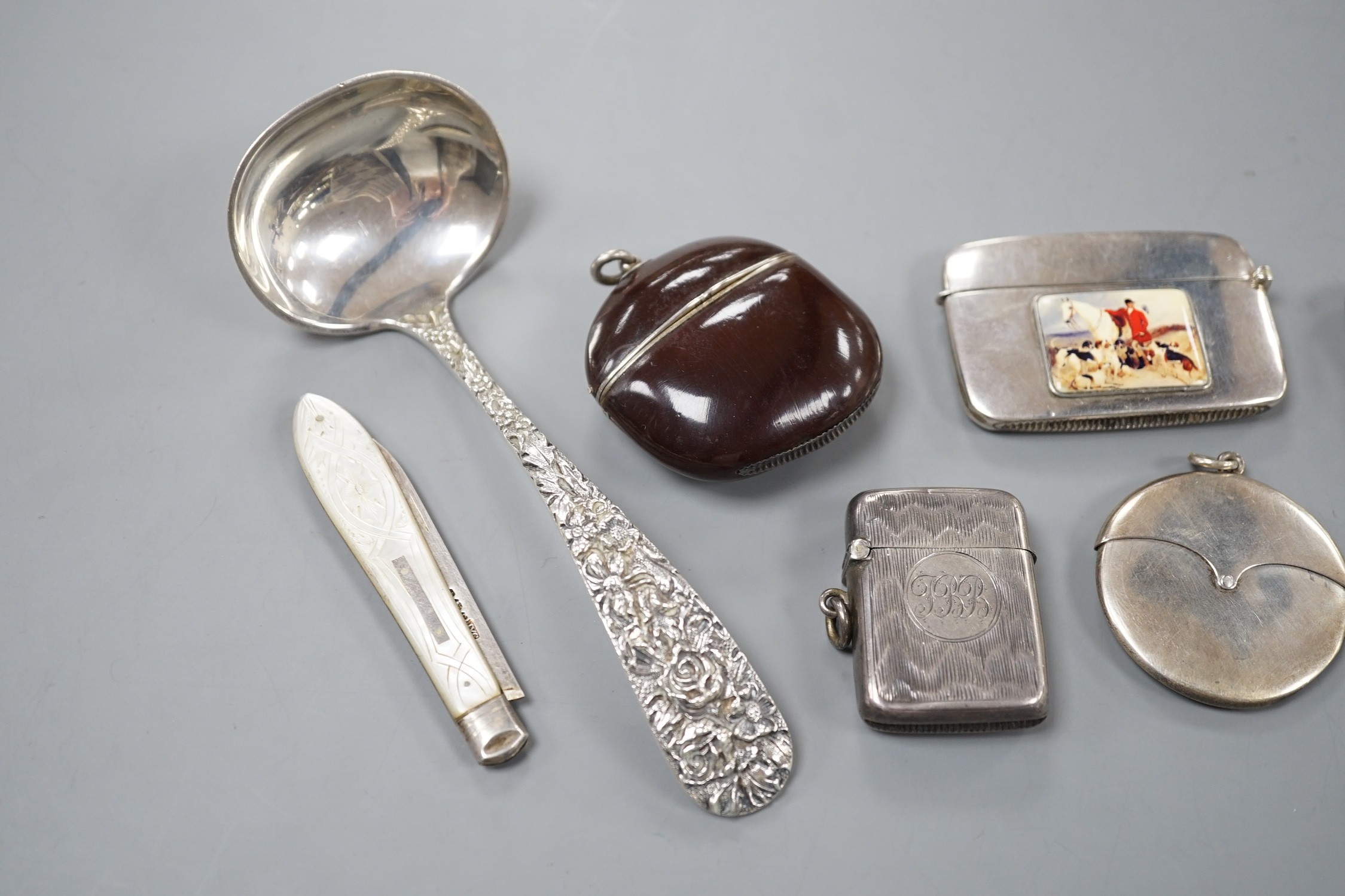 Four assorted early 20th century silver vesta cases, including a silver gilt mounted nut, and patent action circular, together with a sterling vesta case and ornate handled sauce ladle and a mother of pearl handed silver